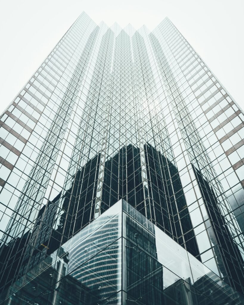 Striking low angle view of a modern skyscraper with reflective glass facade in a cityscape.